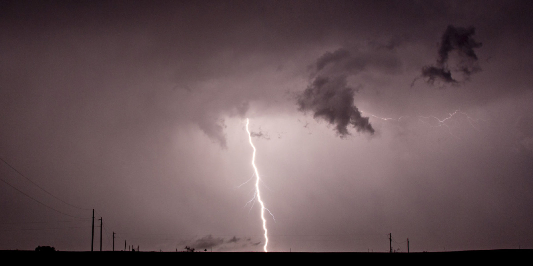 Thunder striking the ground while it is stormy and dark out